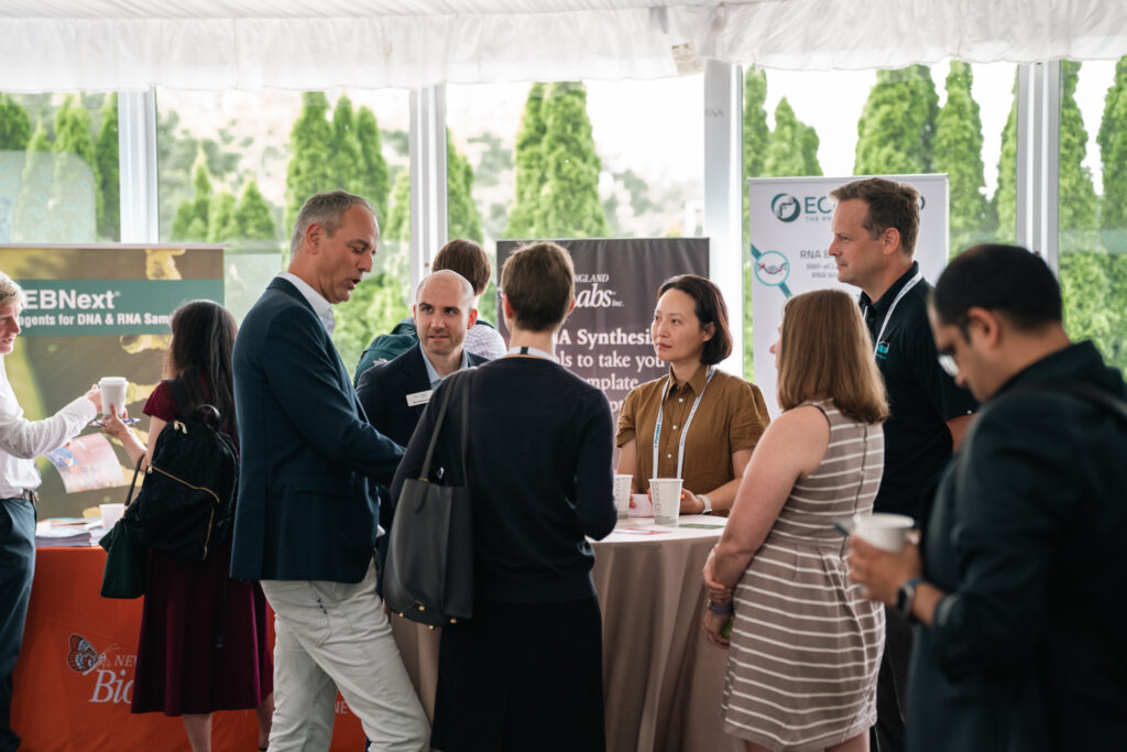 Professionals networking and discussing business opportunities at a life sciences conference exhibition.